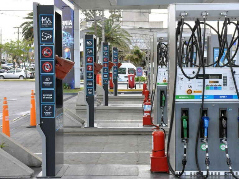 Estación de servicio con surtidores y vehículos cargando combustible