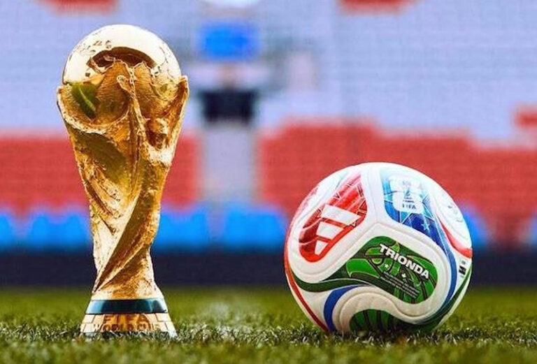 Estadio de fútbol con banderas de países y hoteles al fondo, representando el Mundial 2026